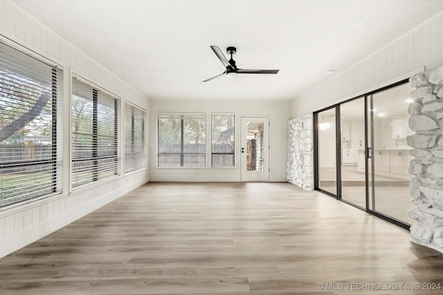 unfurnished sunroom featuring ceiling fan