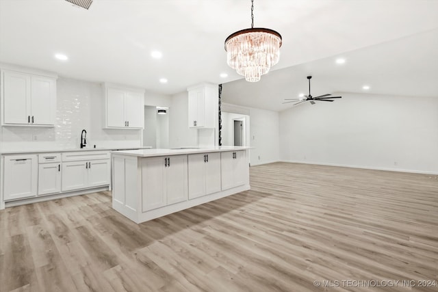 kitchen with white cabinets, light hardwood / wood-style flooring, and lofted ceiling