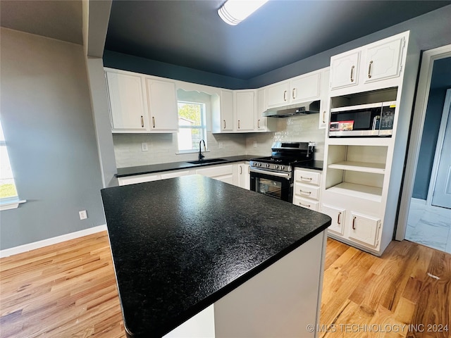 kitchen featuring white cabinetry, sink, tasteful backsplash, light hardwood / wood-style flooring, and appliances with stainless steel finishes