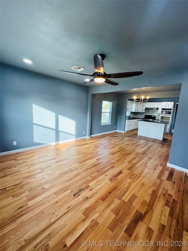 unfurnished living room featuring ceiling fan, light hardwood / wood-style flooring, and sink