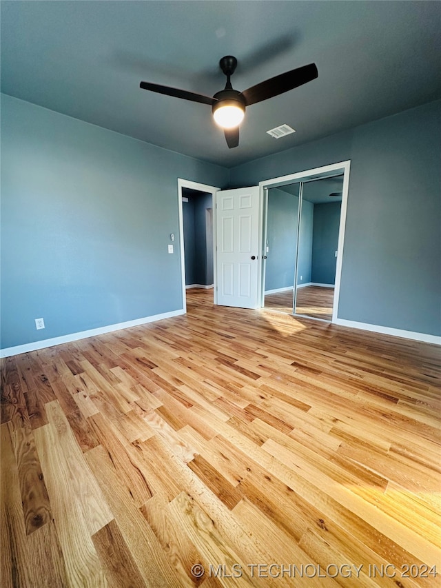 unfurnished bedroom featuring light wood-type flooring, a closet, and ceiling fan