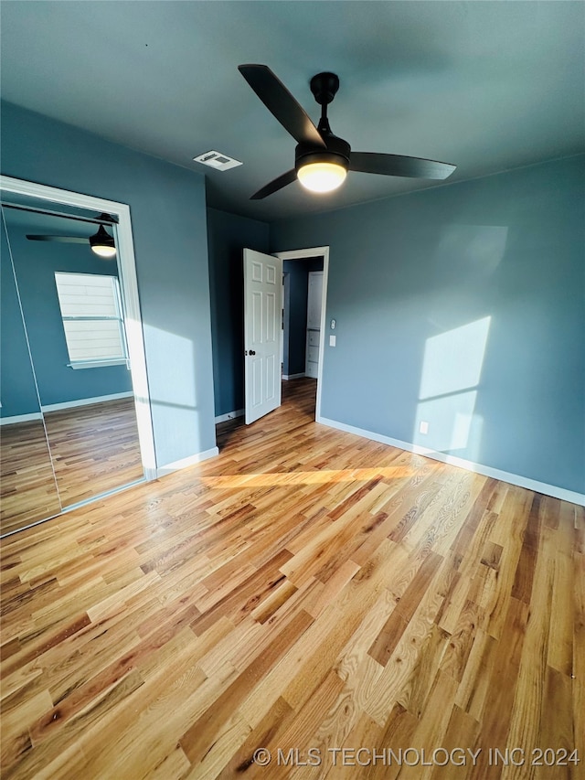 unfurnished bedroom featuring light wood-type flooring, a closet, and ceiling fan