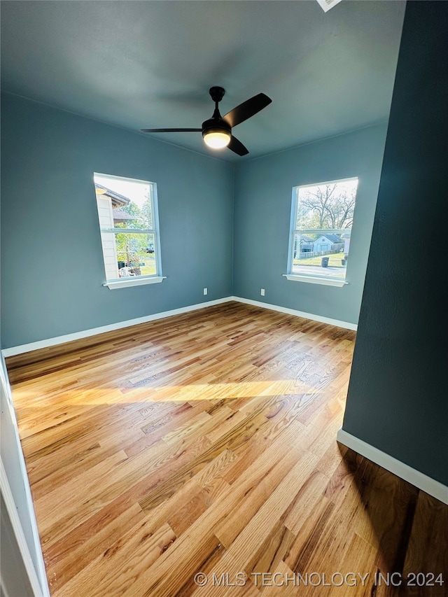 empty room featuring ceiling fan, a healthy amount of sunlight, and light hardwood / wood-style floors