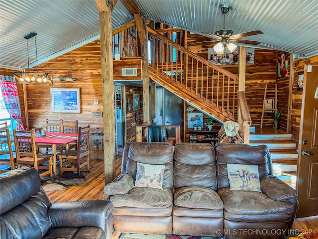 living room featuring lofted ceiling, wooden walls, and wood-type flooring