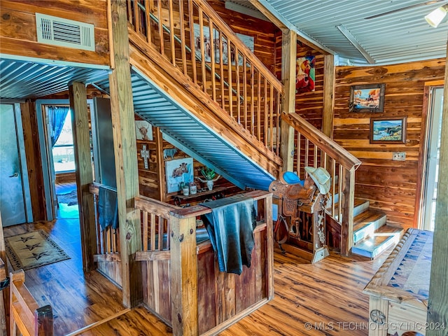 stairway featuring wood walls and wood-type flooring