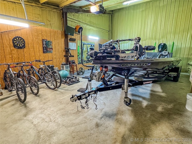 garage featuring a garage door opener and wood walls