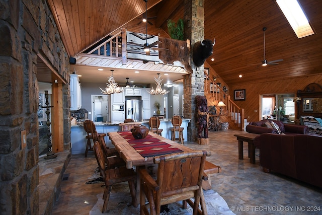 dining room featuring high vaulted ceiling, a skylight, wooden ceiling, and ceiling fan with notable chandelier