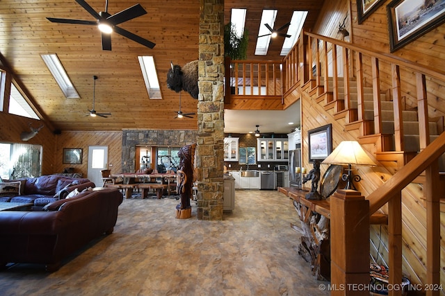 living room with high vaulted ceiling, wooden walls, sink, and wooden ceiling