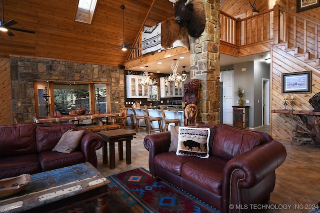 living room with wooden ceiling, ceiling fan with notable chandelier, wood walls, and high vaulted ceiling