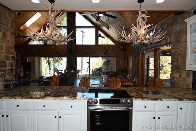 kitchen with a wealth of natural light, stainless steel electric range, and white cabinetry