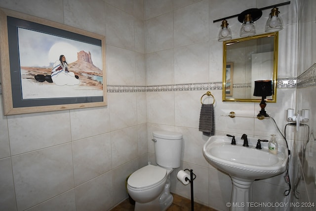 bathroom with tile walls and toilet