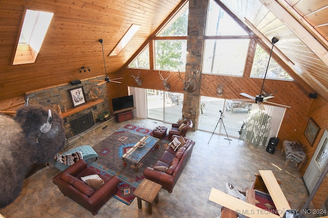 living room featuring wood walls, wooden ceiling, high vaulted ceiling, ceiling fan, and a skylight