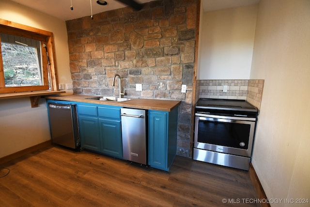 kitchen featuring wooden counters, dark hardwood / wood-style flooring, sink, tasteful backsplash, and appliances with stainless steel finishes