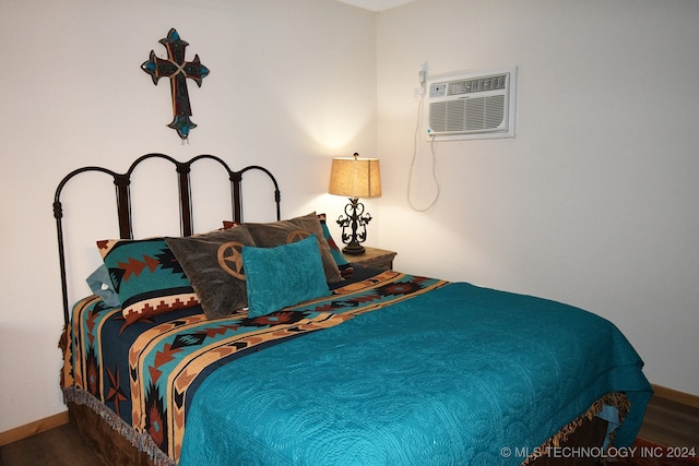 bedroom featuring a wall mounted AC and hardwood / wood-style flooring