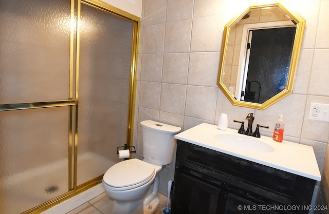 bathroom featuring tile walls, vanity, an enclosed shower, and toilet