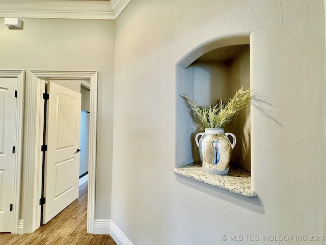 hallway featuring crown molding and light hardwood / wood-style floors