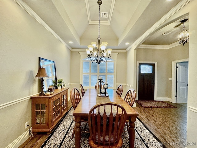 dining room with crown molding, a tray ceiling, dark hardwood / wood-style flooring, and a notable chandelier