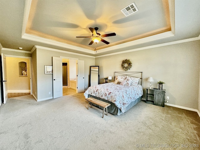 carpeted bedroom featuring a raised ceiling, crown molding, connected bathroom, and ceiling fan