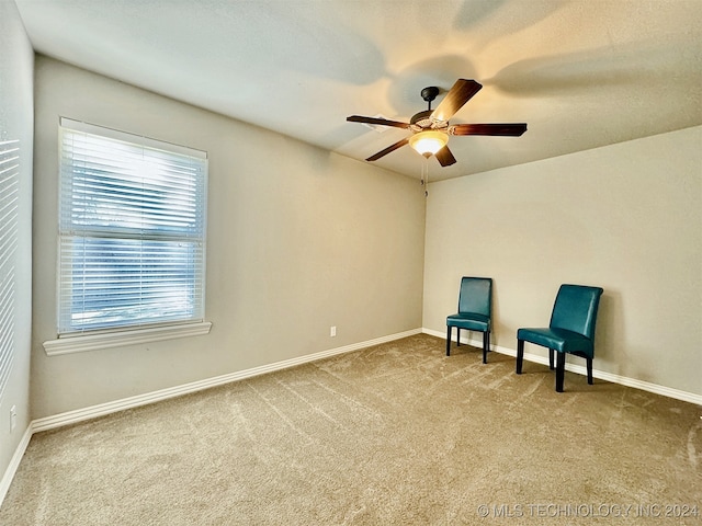 sitting room with ceiling fan and carpet