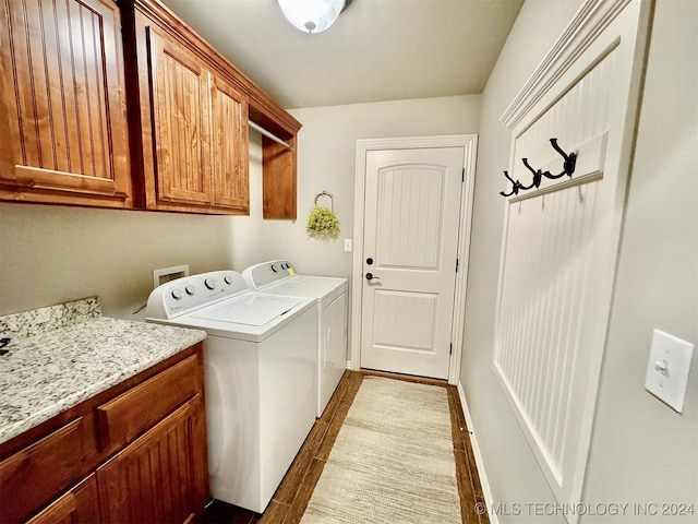 washroom with dark hardwood / wood-style flooring, independent washer and dryer, and cabinets