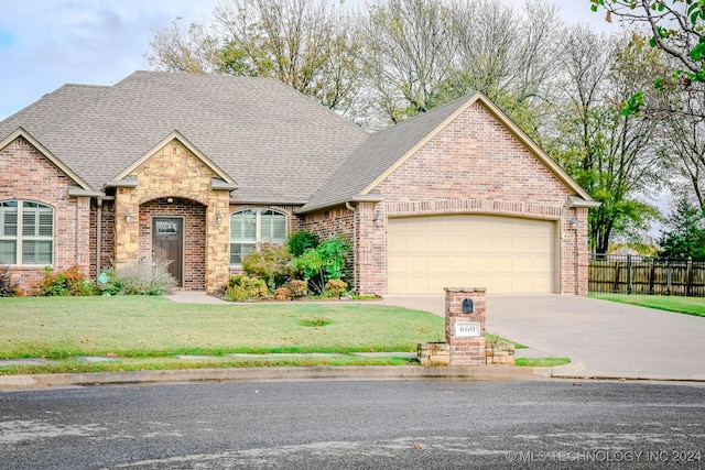 view of front of property featuring a garage and a front lawn