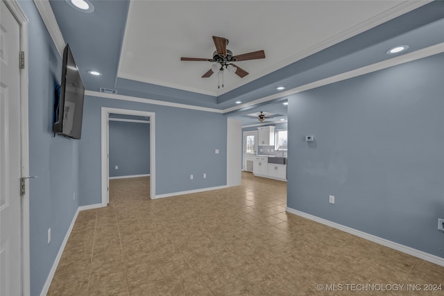 unfurnished living room featuring ceiling fan, sink, and ornamental molding