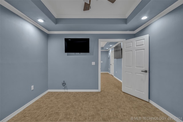 spare room featuring ceiling fan, a raised ceiling, and ornamental molding