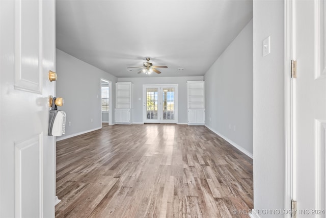 unfurnished living room with french doors, light hardwood / wood-style flooring, and ceiling fan