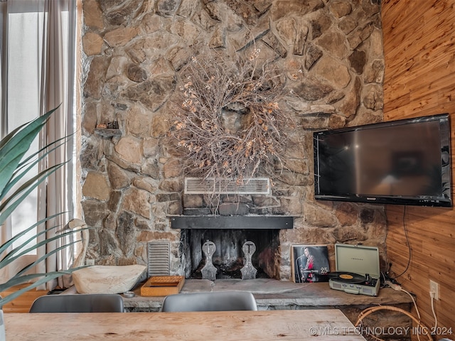 living room featuring a fireplace, wooden walls, and hardwood / wood-style floors