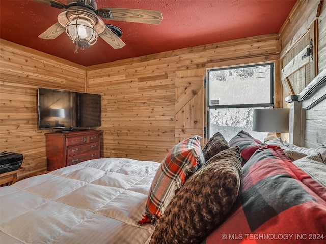 bedroom featuring wood walls and ceiling fan