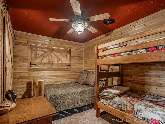 carpeted bedroom with wooden walls and ceiling fan