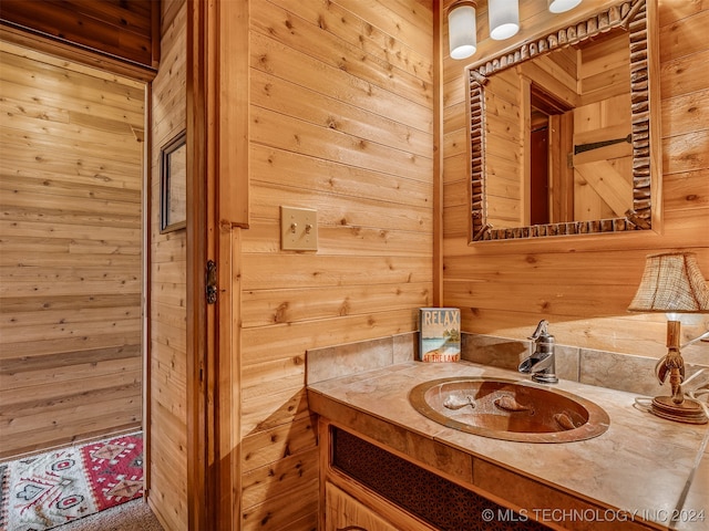 bathroom featuring vanity and wooden walls