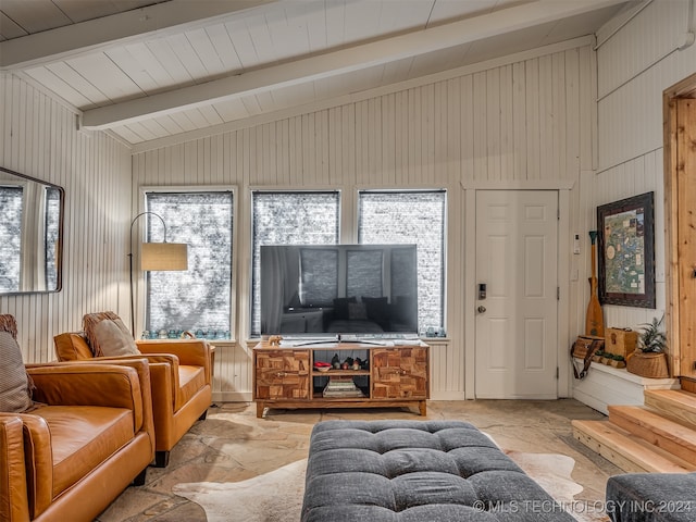 living room with beamed ceiling, wooden walls, and high vaulted ceiling