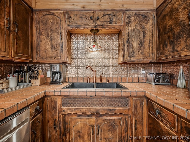 kitchen featuring tile countertops, sink, and decorative backsplash