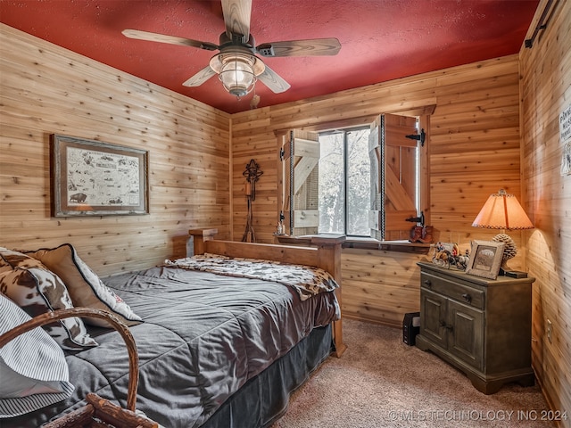 bedroom featuring wooden walls, a ceiling fan, and carpet flooring