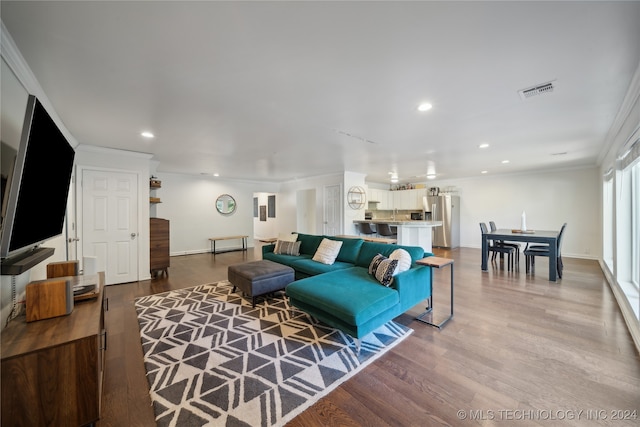 living room featuring ornamental molding and wood-type flooring