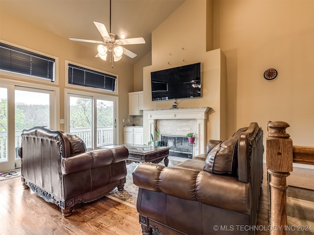 living room with high vaulted ceiling, a fireplace, ceiling fan, and light wood-type flooring