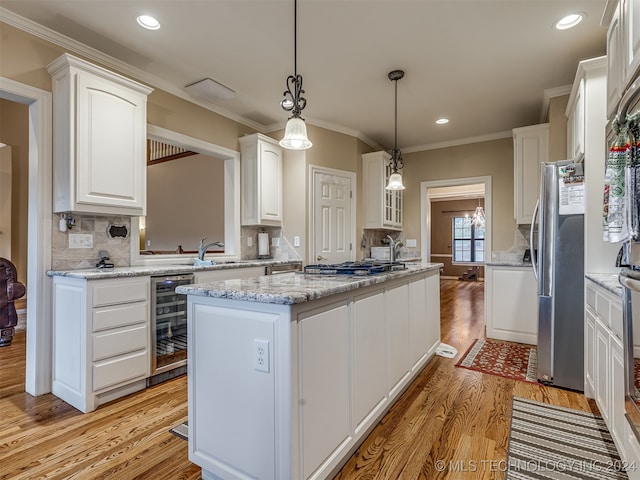 kitchen featuring light hardwood / wood-style floors, a center island, white cabinetry, appliances with stainless steel finishes, and wine cooler