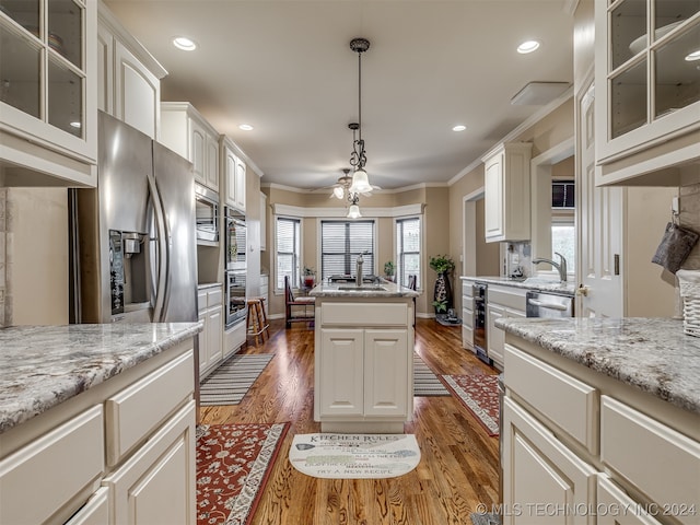 kitchen with stainless steel appliances, sink, ornamental molding, white cabinets, and dark hardwood / wood-style flooring