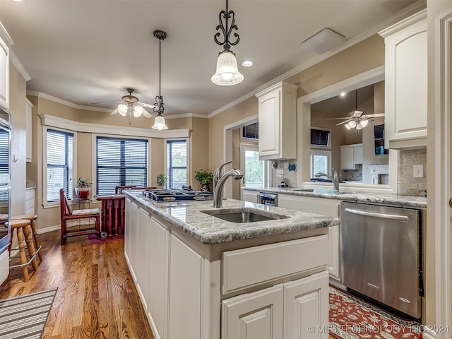 kitchen featuring a center island with sink, sink, appliances with stainless steel finishes, hardwood / wood-style floors, and white cabinets