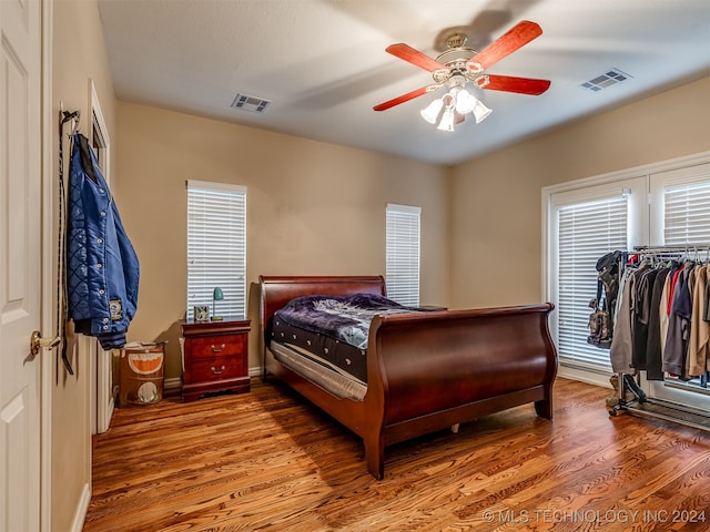 bedroom featuring hardwood / wood-style flooring, ceiling fan, and a closet