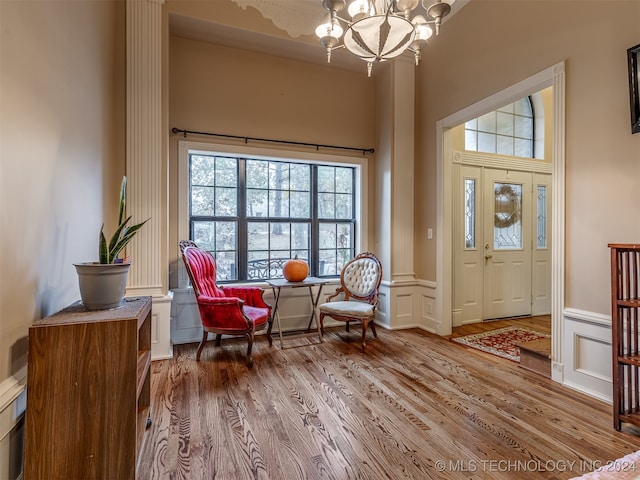 sitting room with wood-type flooring and an inviting chandelier