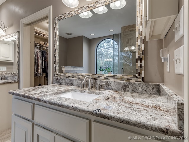 bathroom featuring vanity and backsplash