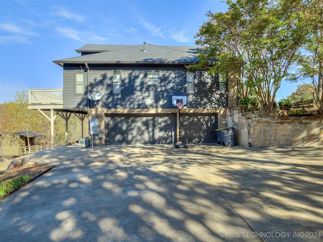 back of property featuring a balcony and a garage