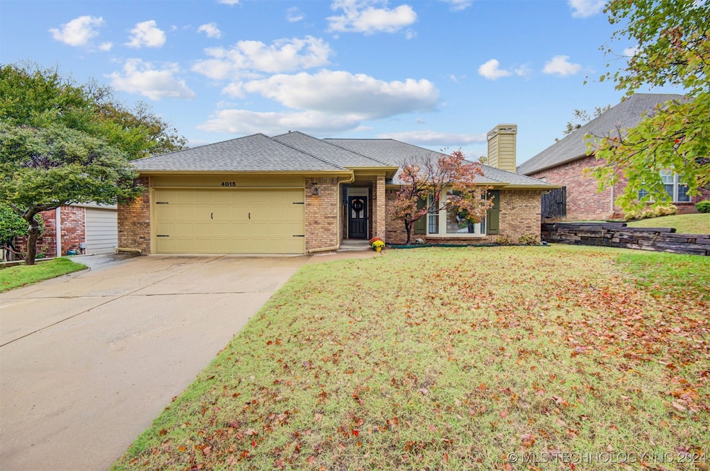 ranch-style house featuring a garage and a front lawn