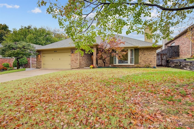 single story home featuring a front lawn and a garage