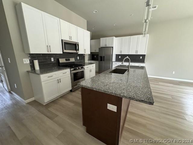 3402 Redbud Ln, Tulsa, OK 74132 - kitchen with appliances with stainless steel finishes, a sink, light wood-style flooring, backsplash, and baseboards
