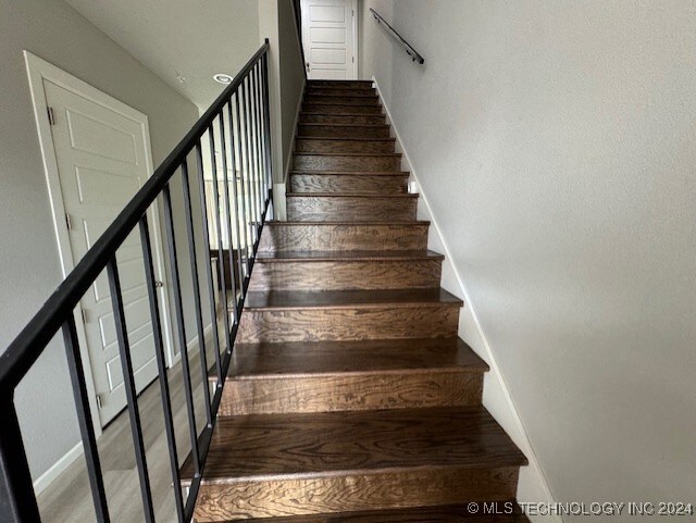 stairway with hardwood / wood-style floors