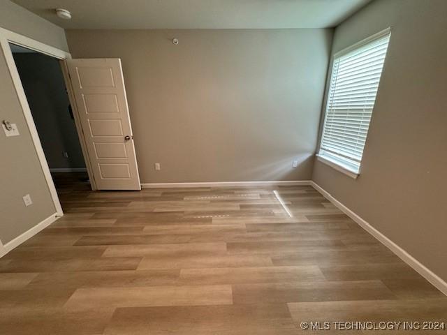 3402 Redbud Ln, Tulsa, OK 74132 - spare room featuring a smoke detector, baseboards, and light wood-style floors