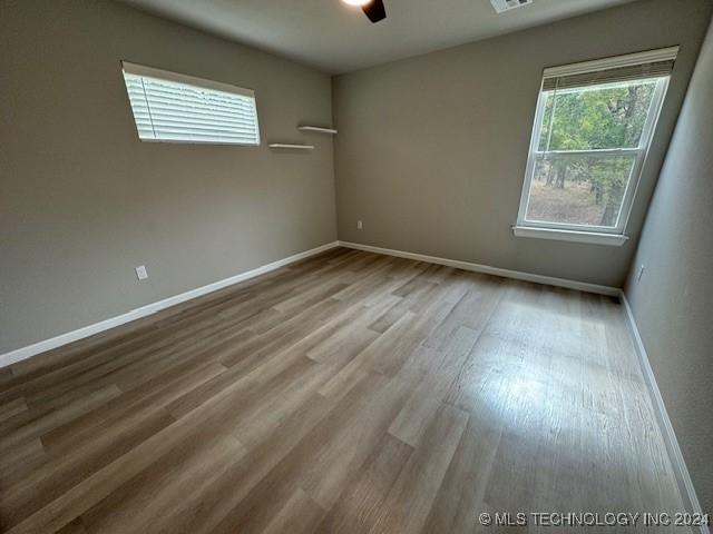 3402 Redbud Ln, Tulsa, OK 74132 - unfurnished room with baseboards, a ceiling fan, and wood finished floors